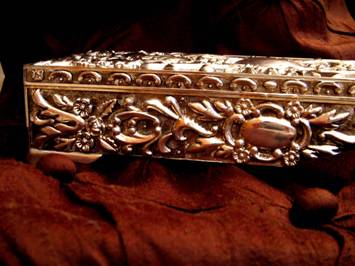 Jewelry Boxes come in all sizes, shapes and materials. This photo of an elegant silver jewelry box (or casket) with repousse detailing was taken by an unknown photographer.